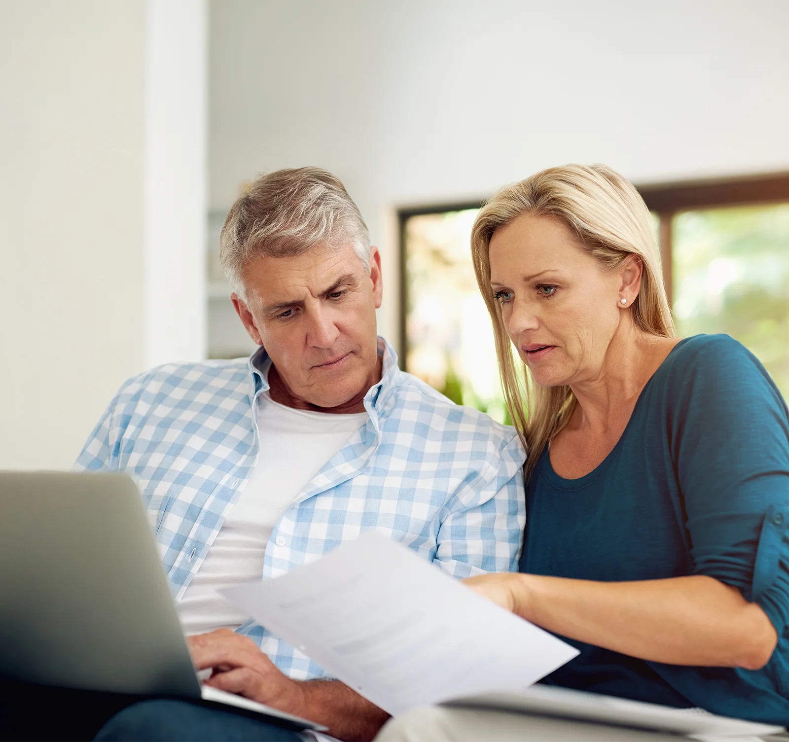 worried mature couple reviewing financials together