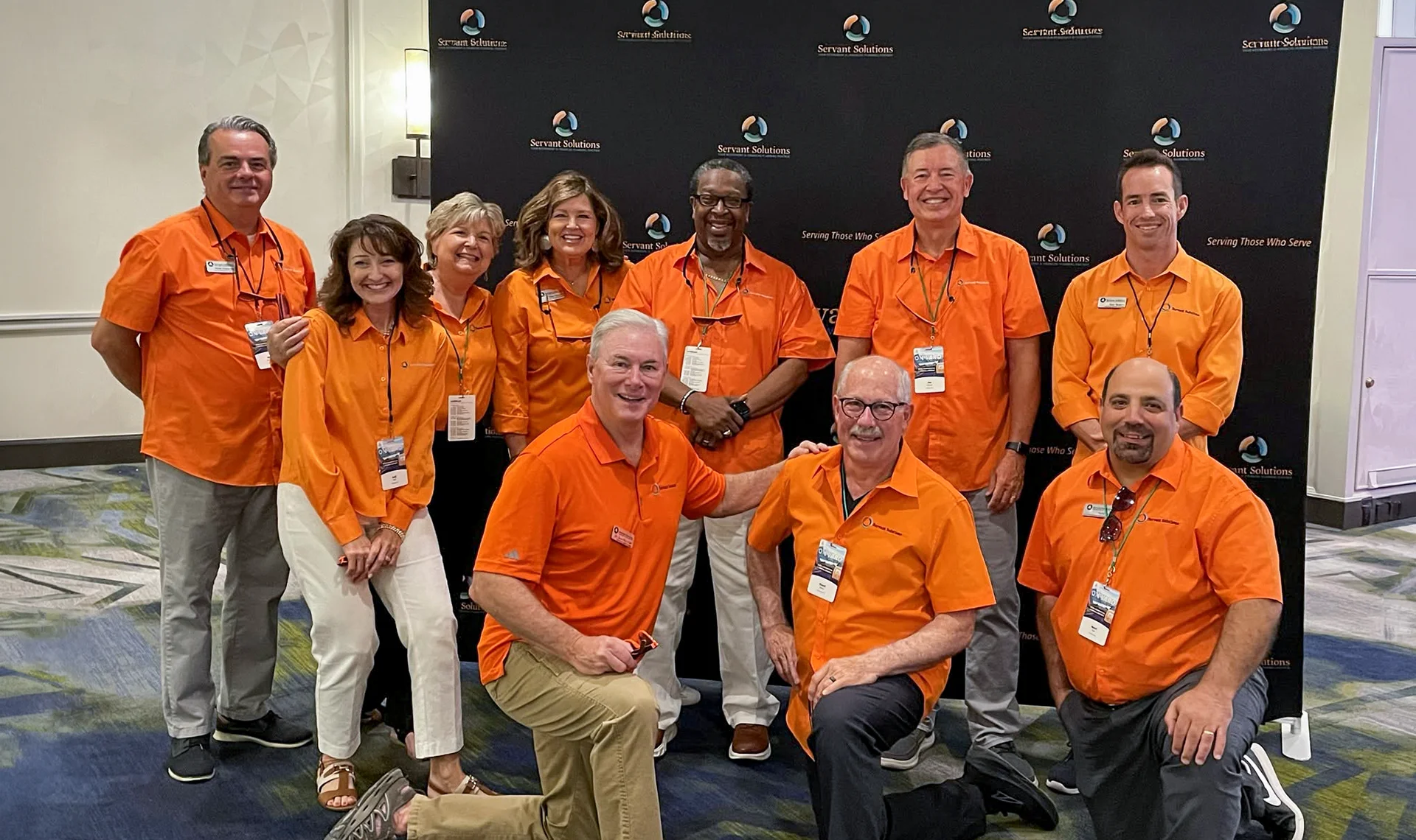 servant solutions team at event in front of backdrop
