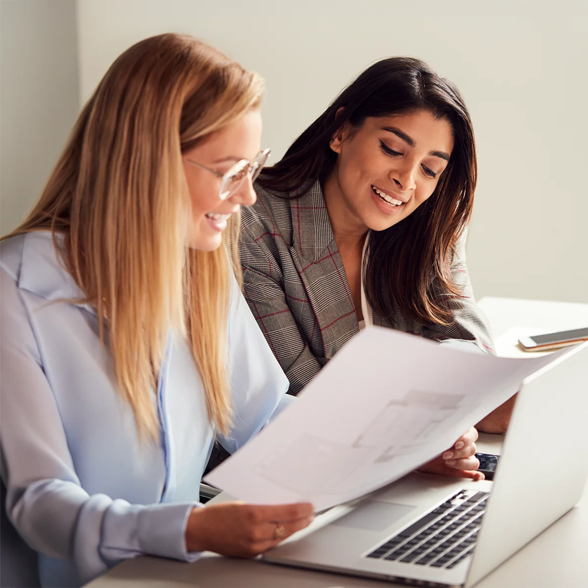 smiling women working together on church compensation planning